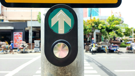 Manual button for pedestrian crossing traffic lights in Indonesia by pressing with blurred background of road trafficの写真素材
