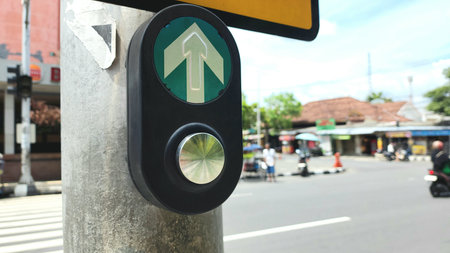 Manual button for pedestrian crossing traffic lights in Indonesia by pressing with blurred background of road trafficの写真素材