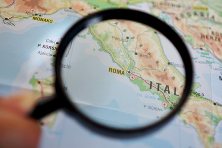 view of Rome, Italy on a geographic map of Europe, seen using a magnifying glassの写真素材