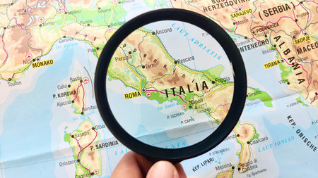 View of Italy, officially the Italian Republic, is a country in Southern and Western Europe, on a geographical map of Europe, seen using a magnifying glassの写真素材