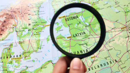 View of Latvia, officially the Republic of Latvia, is a country in the Baltic region of Northern Europe, on a geographical map of Europe, seen using a magnifying glassの写真素材