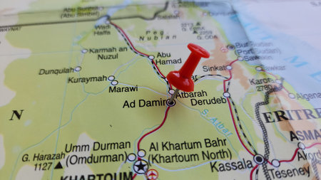 View of Ad-Damir or ad-Damar is the capital of the River Nile state in Sudan, on a geographical map of Africa, marked with red push pinの写真素材