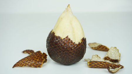 salak fruit or snake fruit or bark fruit that is still intact with its skin that is like a snake's skin and a little prickly, and another that has been peeled and bittenの写真素材