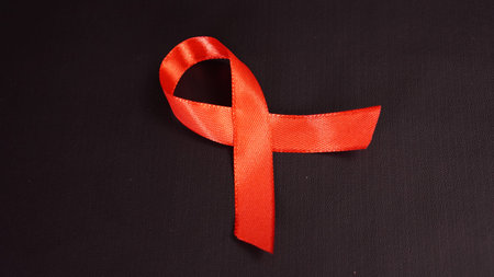 red ribbon symbol of World AIDS Day, isolated on black background