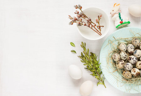 Easter background layout with free text space. Willow branches with catkins, quail eggs, boxwood and...