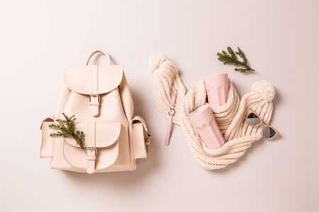 Winter or autumn fashion accessories - christmas gifts. White leather backpack, woollen scarf, pastel pink  mugs, watch and sunglasses. Captured from above (top view, flat lay) on grey background.の写真素材