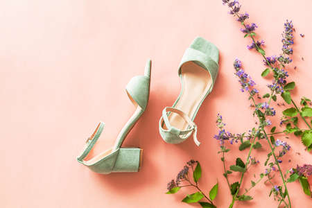 Fashion - summer footwear for woman. Pastel mint green sandals shoes and meadow flowers on bright pink background. Free copy (text) space.の写真素材