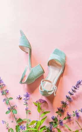 Fashion - summer footwear for woman. Pastel mint green sandals shoes and meadow flowers on bright pink background. Poster with free copy (text) space.の写真素材