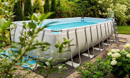 Long, above ground, rectangular, rack (frame) swimming pool outdoor in the garden. Summer holiday (vacation) and recreation.の写真素材