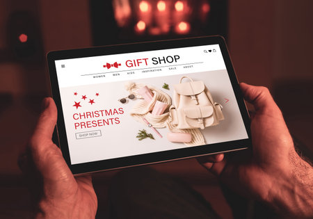 Buying Christmas presents (fashion accessories) online - internet gift shop. Tablet in man's hands. Made up illustrative e-commerce content design.の写真素材