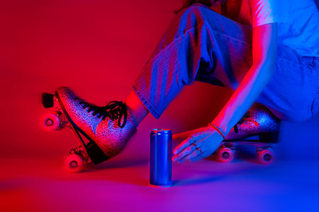 Roller skater reaching for a soda drink in a can while skating. Sports and recreation - saturated red and blue, pop art style poster.の写真素材
