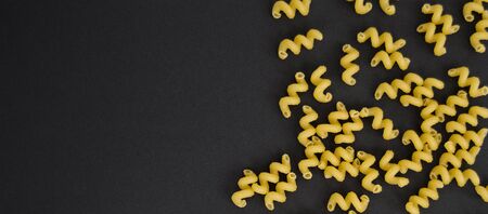 Spaghetti spirals on a black background. Top Viev. Horizontal photo.の写真素材