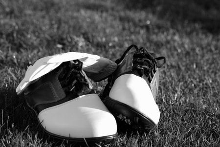 classic black and white photo of golf shoes and glove for the hungry golferの写真素材