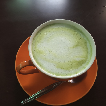 Orange cup of green tea on a black backgroundの写真素材