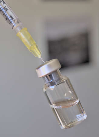 Vaccine bottle and syringe with injection fluid and aluminum cap_Yellow syringeの写真素材