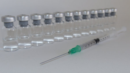 Vaccine bottles and syringe with injection fluid and aluminum caps_vaccination
