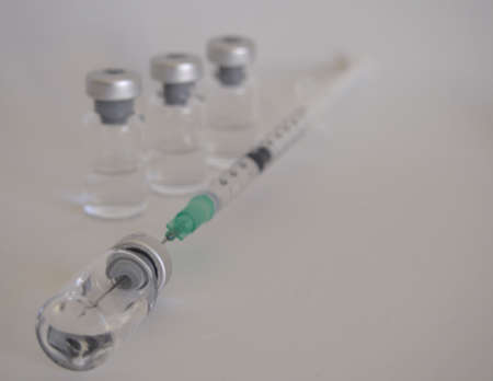 Vaccine bottles and syringe with injection fluid and aluminum capsの写真素材