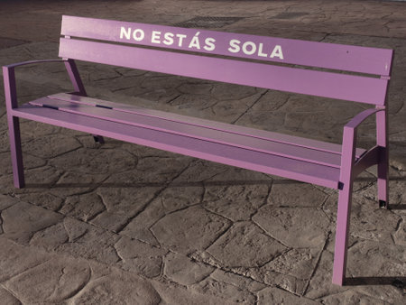 Purple bench as a simbol for claiming Stop Violence against woman. You are not alone. Violet bank as a cry You are not alone, Enough gender violence.の写真素材