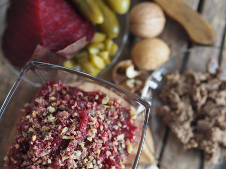 Salad roast beetroot, liver, nuts and pickles. Home kitchen. Wooden background.