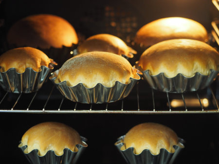 Cooking Easter cakes at home. Fresh pastry for Easter cakes with cookie cutters on a wooden...