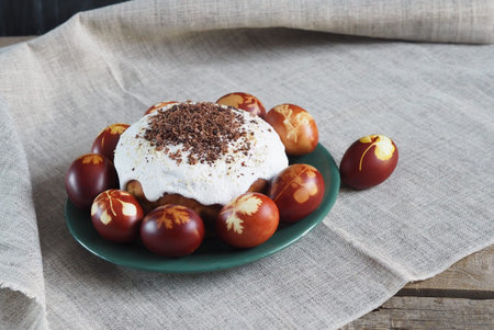 Easter. Traditional Easter pastries and painted onion peeled eggs on a natural tablecloth. Wooden...