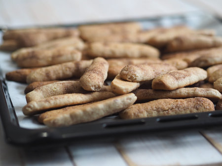 Homemade shortbread biscuits with cinnamon and nuts on a black baking sheet for the oven. Home...