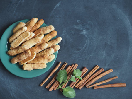 Homemade shortbread biscuits with cinnamon and nuts against a dark background. Cinnamon with mint....