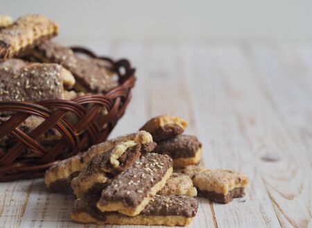 Homemade sandwich puff pastry chocolate cookies in a wicker natural basket of vines. Wooden ancient rustic table.の写真素材