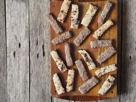 Homemade shortbread puff pastry chocolate chip cookies on a cutting kitchen board. Wooden ancient rustic table. View from above.の写真素材