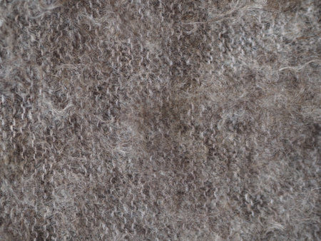 Fragment of a knitted fabric of a fluffy shawl handmade from natural goat hair of brown color. View...