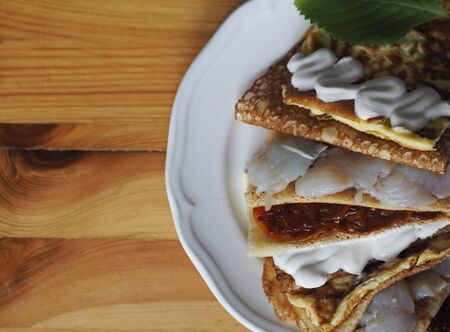 Pancakes stuffed with fish, scrambled eggs, tomatoes on a dark kitchen cutting board. A stack of pancakes. Background for Shrovetide. Seeing the winter, we meet spring.Place for text.の写真素材