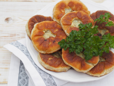 Belyasha homemade baking with meat on a white rustic wooden table. View from above.