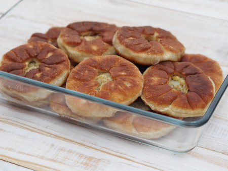 Belyasha homemade baking with meat on a white rustic wooden table. Side view.