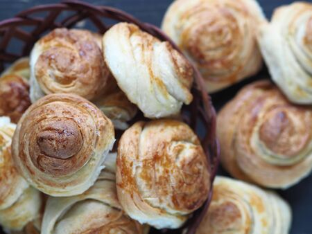 Homemade buns buns rich in a natural plate of vines on a dark wooden background. Holiday and everyday food. View from above.の写真素材