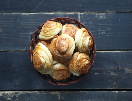 Homemade buns buns rich in a natural plate of vines on a dark wooden background. Holiday and...