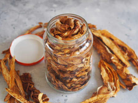 Dried melon chips in a glass jar on a wooden background. Home cooking. Natural healthy product....