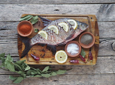 Close-up. Raw river fish of bream cooked for baking in the oven with slices of lemon and seasoning...