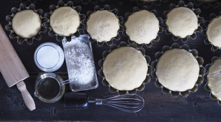 Concept of culinary background. The view from the top.Baking ingredients and raw rolls in molds on a...