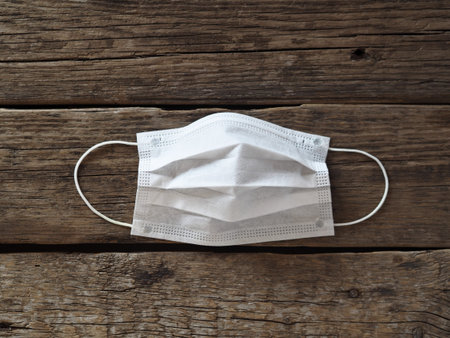 Medical face mask from flu virus on wooden ancient natural background. Coronavirus 2020.
