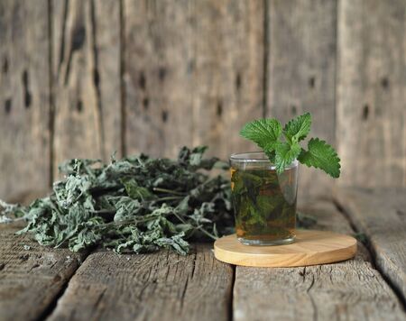 Drug plants. Herbal tea with dried Melissa or mint on a natural wooden table.の写真素材
