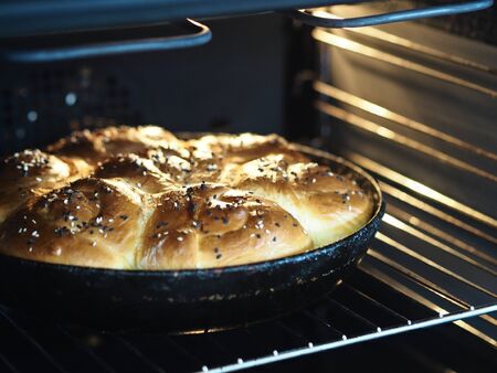 Homemade pies in round pan in the oven baked. Buns from yeast dough.の写真素材