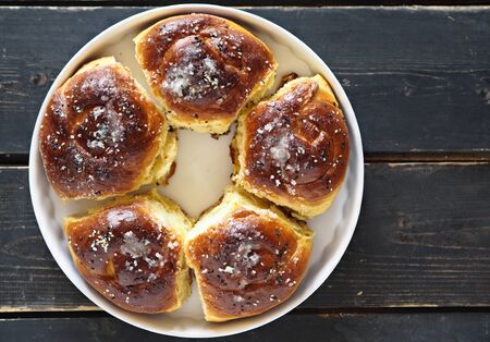 Homemade cake. The view on top of buns ,sprinkle with sesame seeds and sugar syrup on the dark table.の写真素材