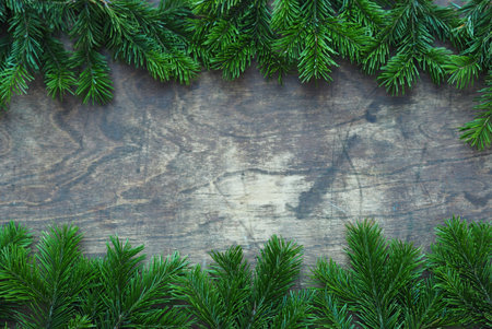 New Years greetings. Fir branches are laid out on a brown background with a place for text.