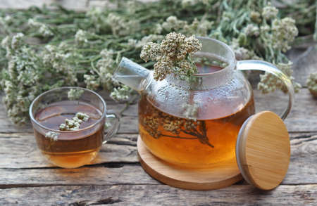 Herbal medicinal background.Healthy tea with yarrow flowers on a wooden rustic table. Place for text.の写真素材