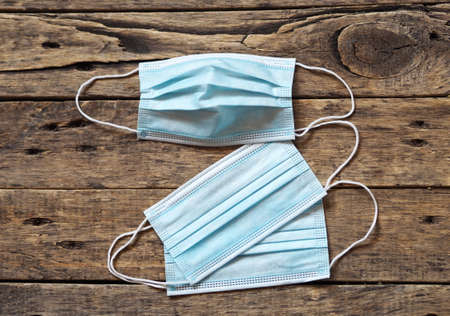 Medical background. Observe the mask mode and protect yourself from the virus. Protective medical masks on a wooden natural background.の写真素材