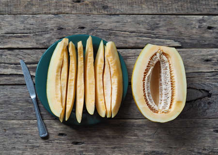 Food background.Melon slices on wooden natural background.の写真素材