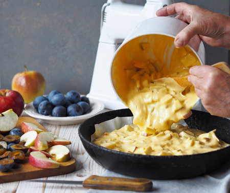 Preparing for a holiday or meeting guests. The process of making charlotte with apples and plums....