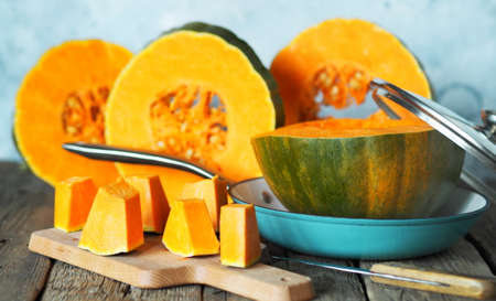 Sliced orange pumpkin in a frying pan on a gray background. Autumn background.の写真素材