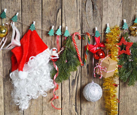 On the eve of Christmas, Santa's hat, spruce branches and New Year's decorations suspended from a rope with clothespins are aired. Santa Claus is preparing for the holiday.の写真素材