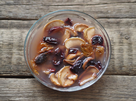 Kissel with dried fruits in a glass plate on a wooden background. Healthy natural homemade dessert....